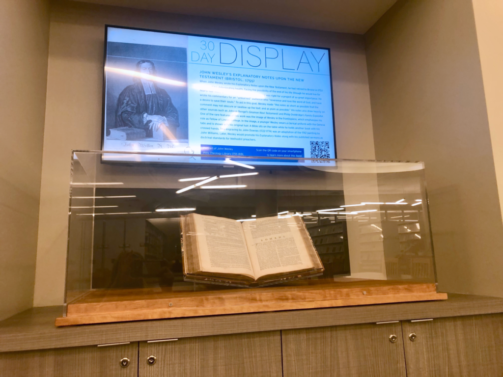 photo of library exhibit with glass case and digital screen